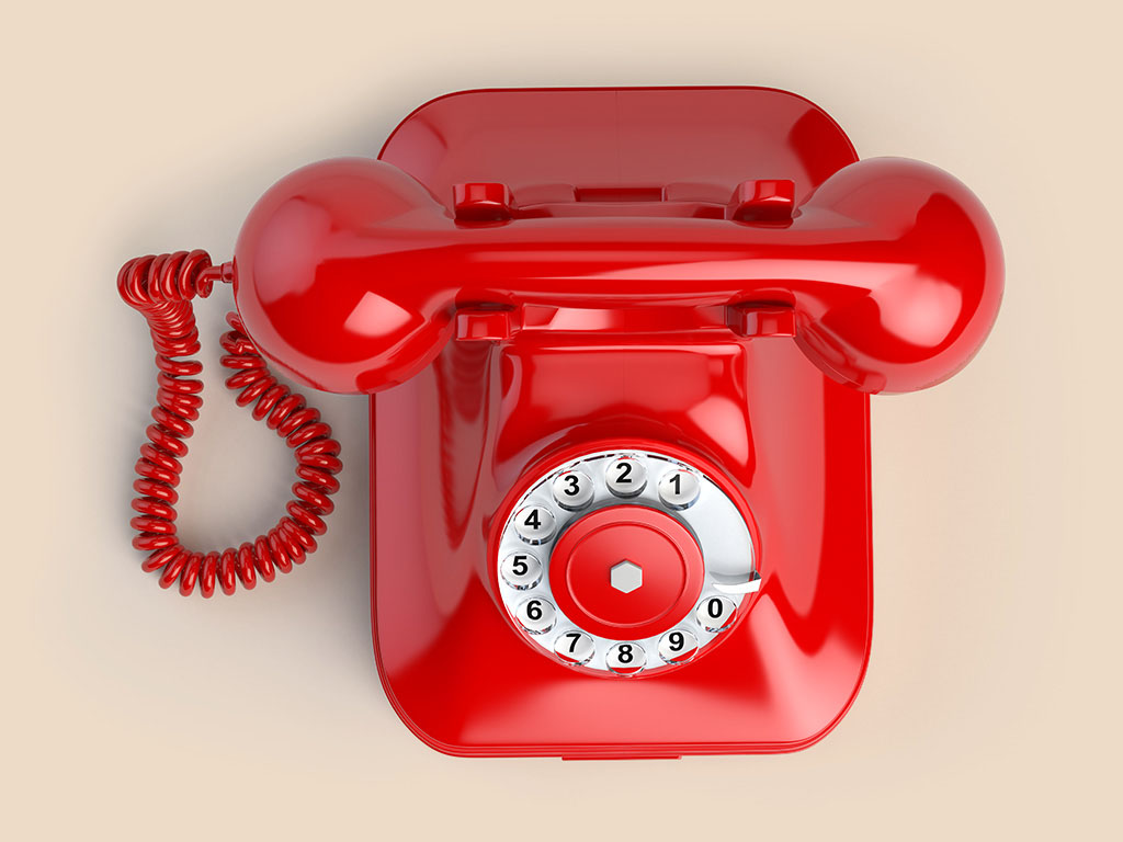 Red vintage telephone isolated on white. Top view of phone